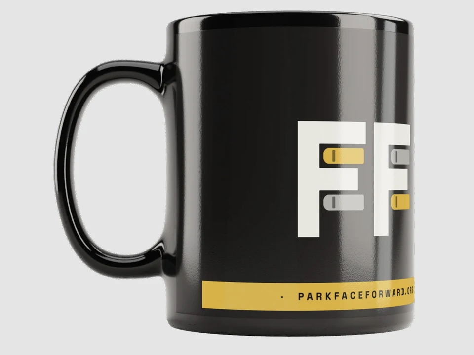 Black glossy Face Forward mug with the Double-F mark and Safety Gold website stripe.